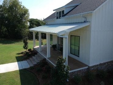 side drone footage of large farm house with new metal roof by conway roofing company collier roofing